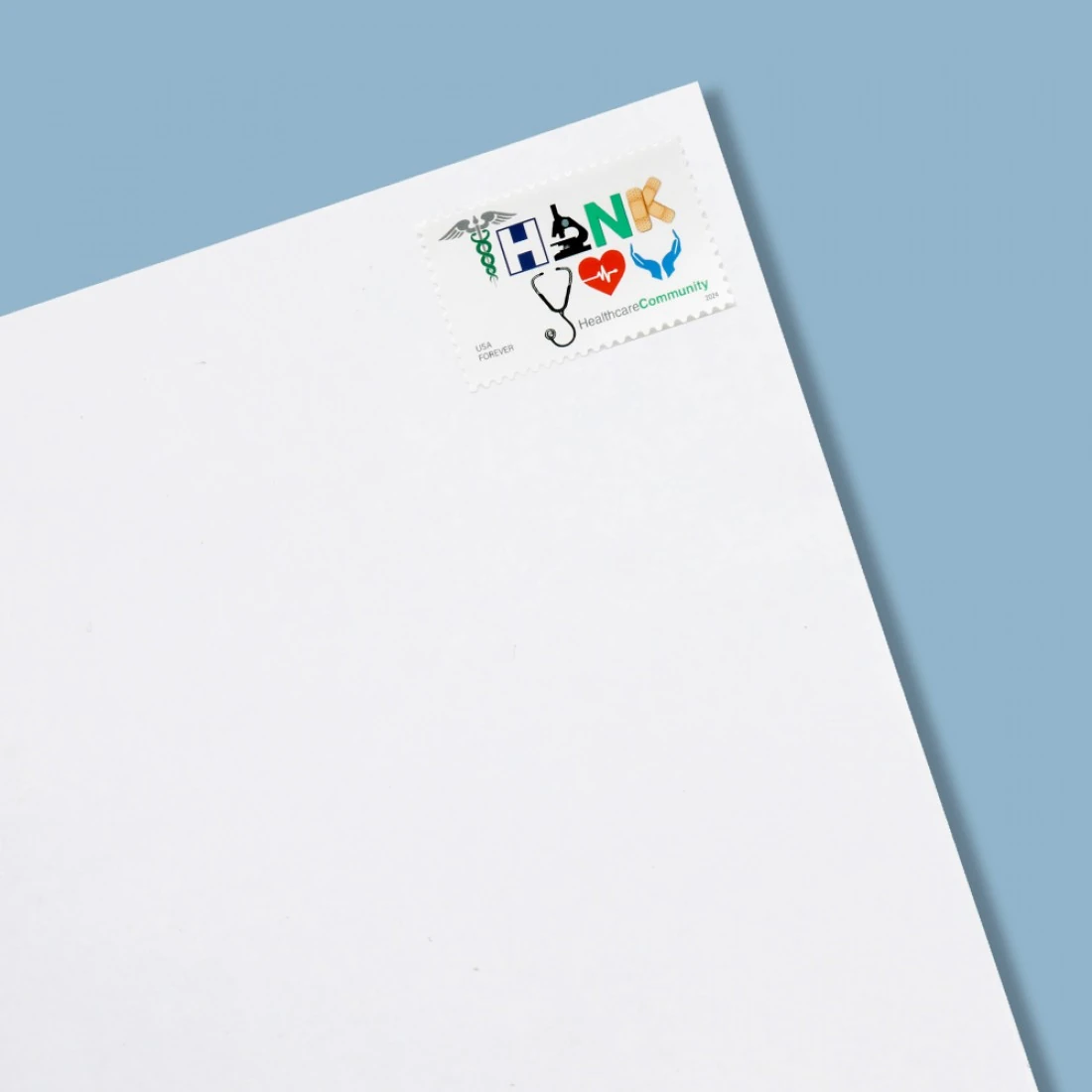 collector using tongs to handle a pane of betty white usps forever stamps